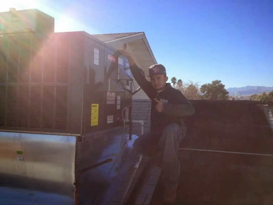 HVAC technician performing Heat Pump Repair on a rooftop unit in Celina